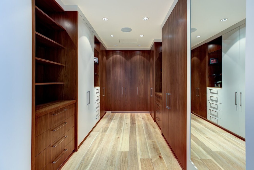 Imagen de armario y vestidor actual grande con armarios con paneles lisos, puertas de armario de madera oscura y suelo de baldosas de cerámica
