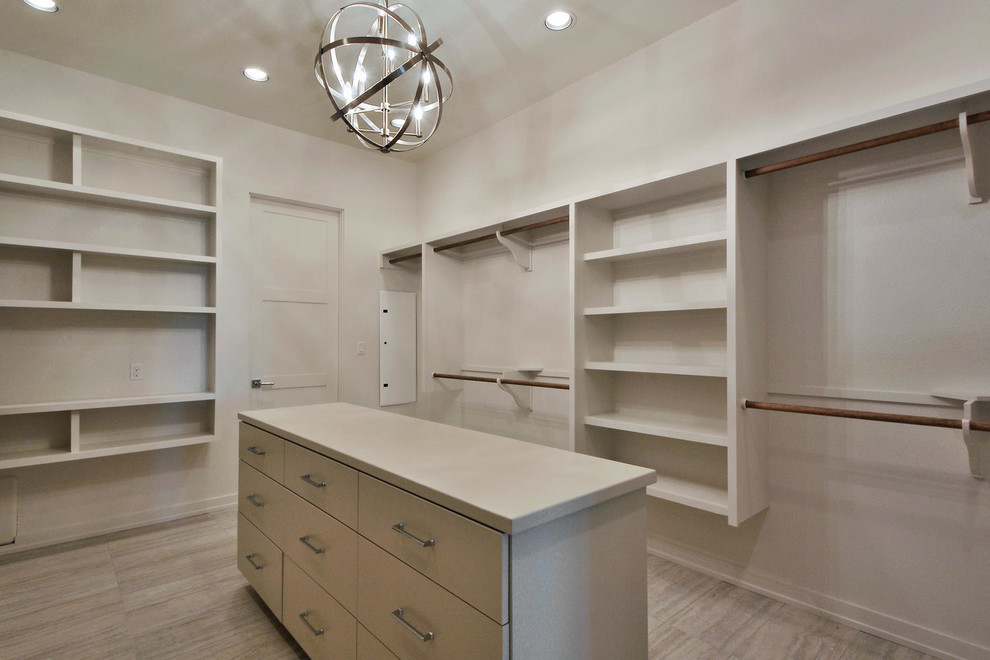 Large contemporary gender neutral walk-in wardrobe in Austin with flat-panel cabinets, beige cabinets and porcelain flooring.