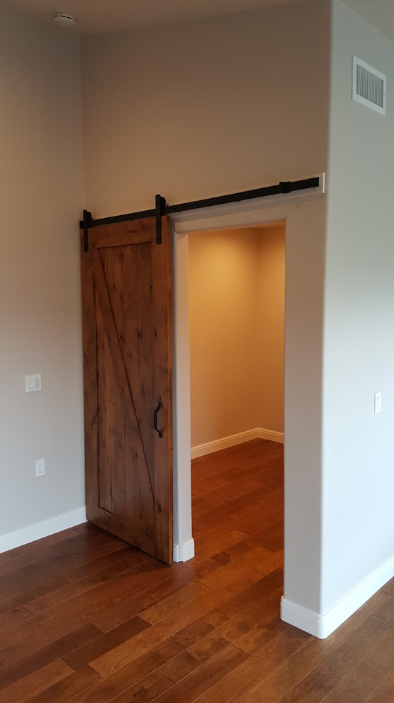Foto di una cabina armadio unisex classica di medie dimensioni con ante con bugna sagomata, ante in legno chiaro e parquet chiaro