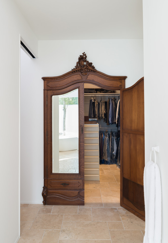 Пример оригинального дизайна: гардеробная комната унисекс в стиле модернизм с полом из травертина