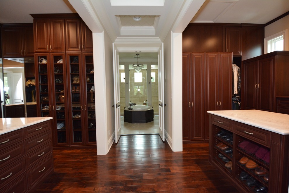 Large elegant gender-neutral dark wood floor walk-in closet photo in Tampa with raised-panel cabinets and dark wood cabinets