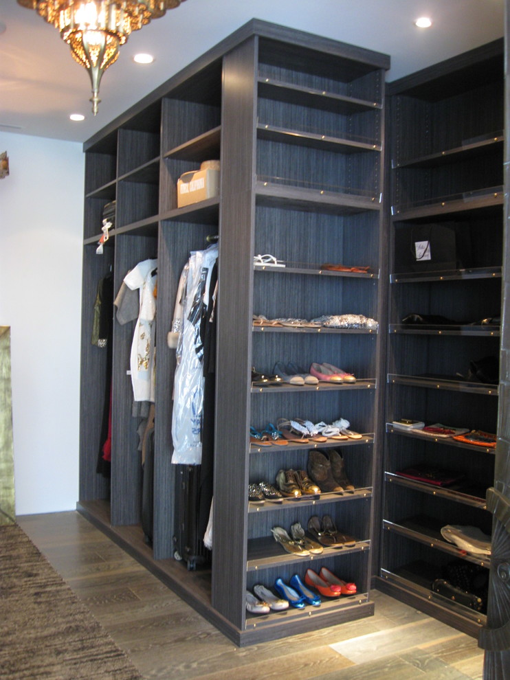 Ejemplo de armario vestidor unisex actual extra grande con puertas de armario de madera en tonos medios, armarios abiertos, suelo de madera oscura y suelo marrón
