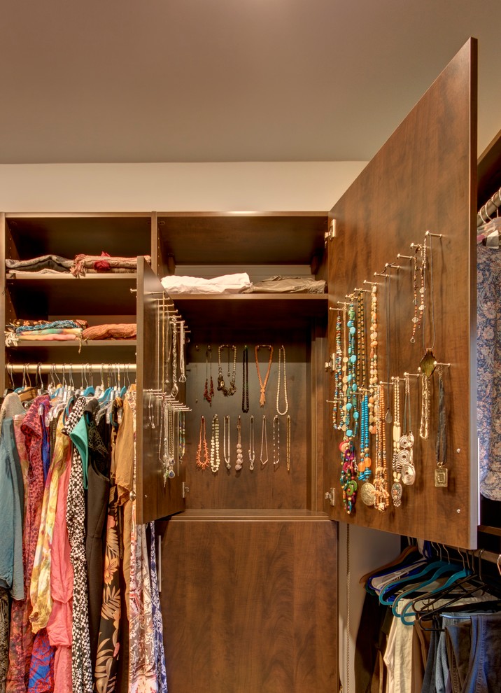 Modelo de armario vestidor unisex tradicional grande con armarios con paneles lisos, puertas de armario de madera en tonos medios, suelo de madera en tonos medios y suelo marrón