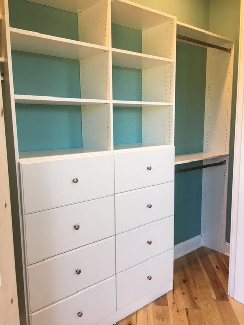 Imagen de armario unisex clásico grande con armarios con paneles lisos, puertas de armario blancas, suelo de madera en tonos medios y suelo marrón