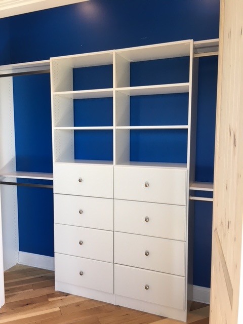 Foto de armario unisex clásico grande con armarios con paneles lisos, puertas de armario blancas, suelo de madera en tonos medios y suelo marrón