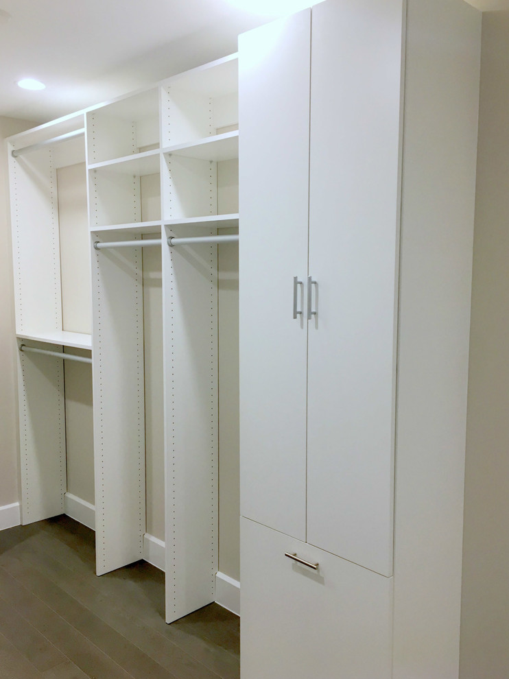 Large contemporary gender neutral walk-in wardrobe in Other with white cabinets.