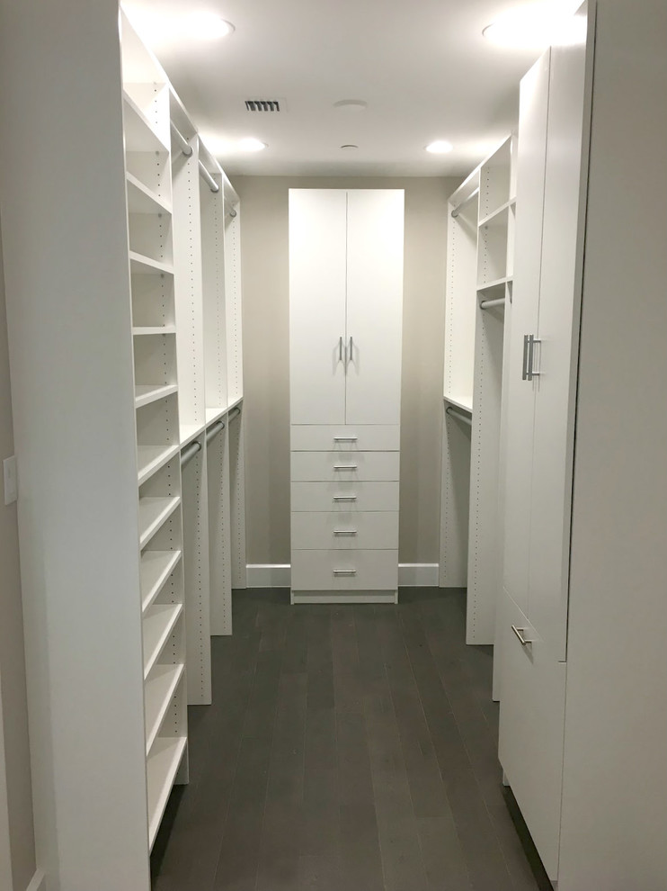 Design ideas for a large contemporary gender neutral walk-in wardrobe in Other with white cabinets.