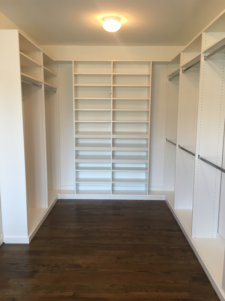 Imagen de armario y vestidor minimalista grande con a medida, puertas de armario blancas y suelo de madera oscura
