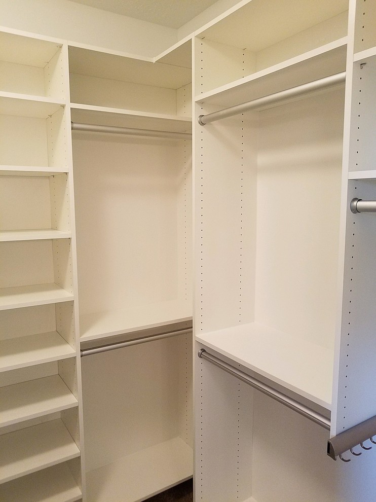 Foto de armario vestidor unisex actual grande con armarios con paneles lisos, puertas de armario blancas, moqueta y suelo beige