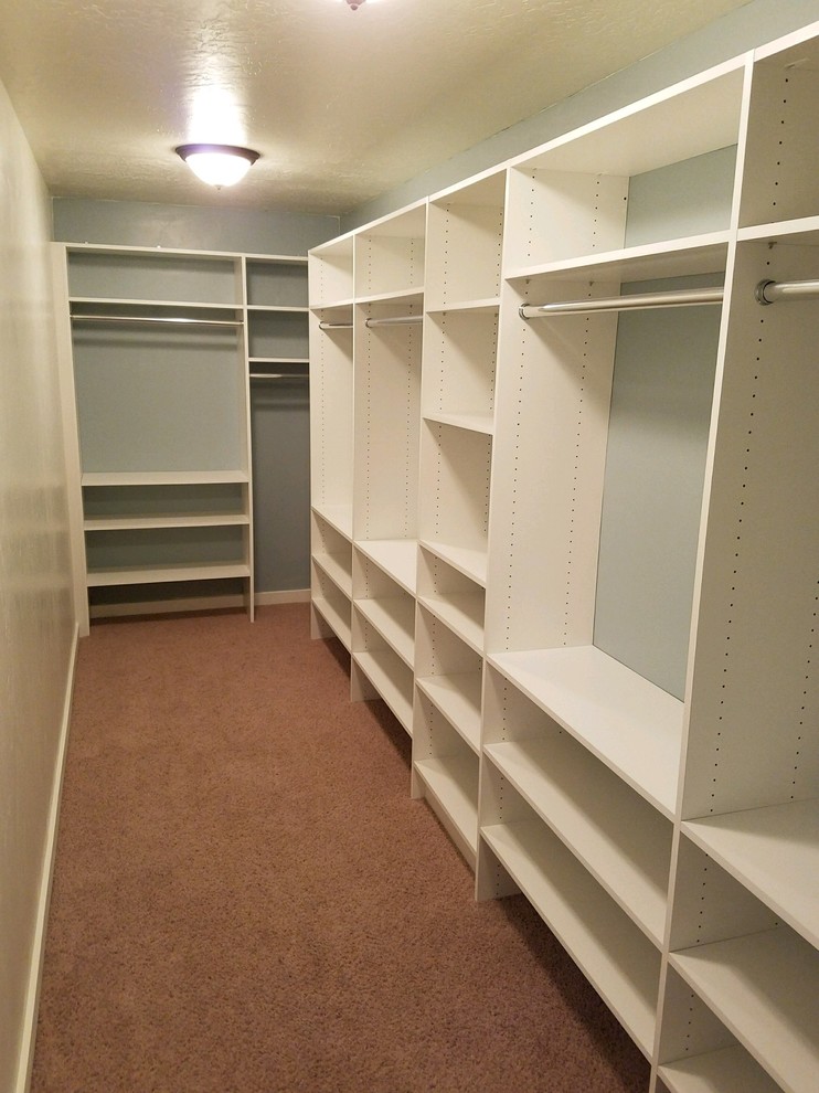 Example of a large trendy gender-neutral carpeted and beige floor walk-in closet design in Other with flat-panel cabinets and white cabinets