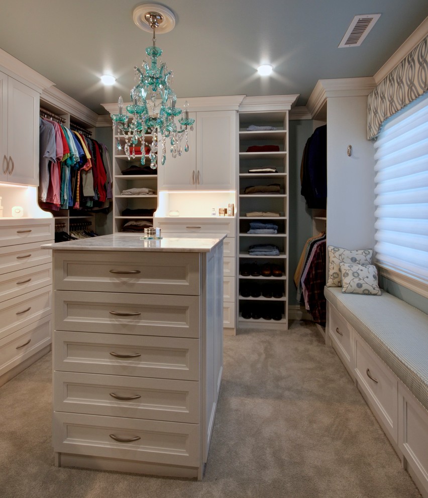 Ejemplo de armario vestidor unisex tradicional grande con puertas de armario blancas, moqueta, suelo beige y armarios con paneles empotrados