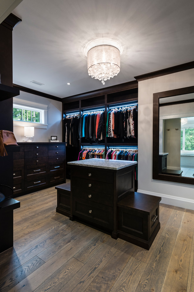 Large elegant gender-neutral medium tone wood floor and brown floor dressing room photo in Vancouver with recessed-panel cabinets and dark wood cabinets
