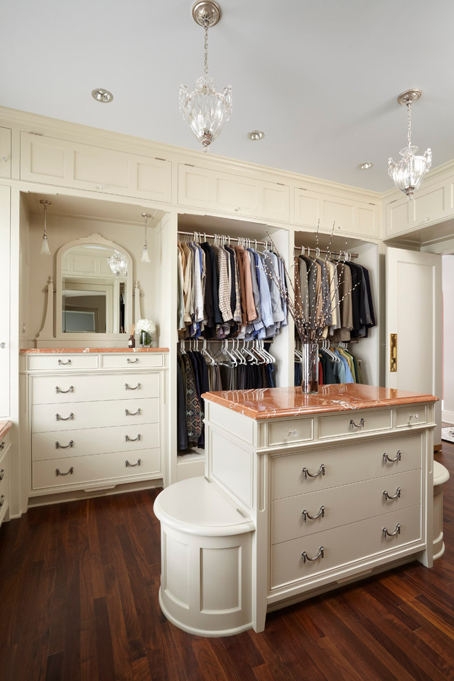 Imagen de vestidor de mujer clásico con armarios abiertos y puertas de armario beige