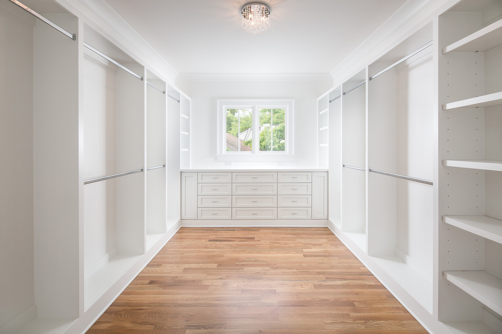 Design ideas for an expansive traditional walk-in wardrobe in Atlanta with recessed-panel cabinets, white cabinets and medium hardwood flooring.