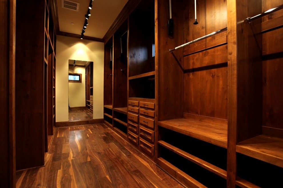 Huge elegant women's medium tone wood floor walk-in closet photo in Houston with recessed-panel cabinets and medium tone wood cabinets