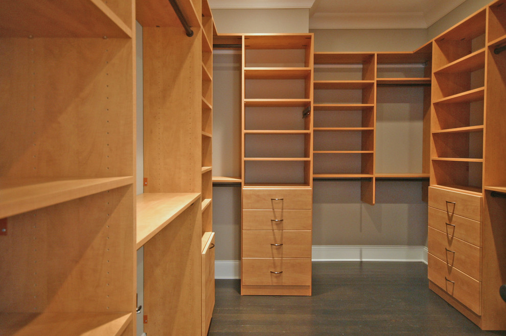 Example of a mid-sized classic gender-neutral dark wood floor walk-in closet design in Chicago with flat-panel cabinets and medium tone wood cabinets