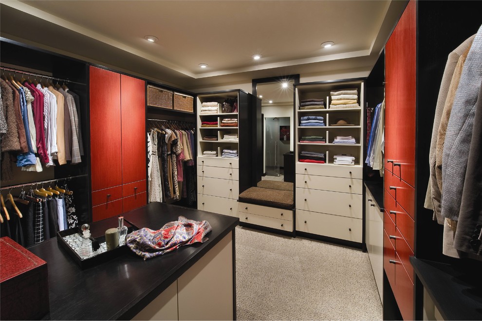 Design ideas for a large contemporary gender neutral walk-in wardrobe in Houston with flat-panel cabinets, red cabinets, carpet and beige floors.