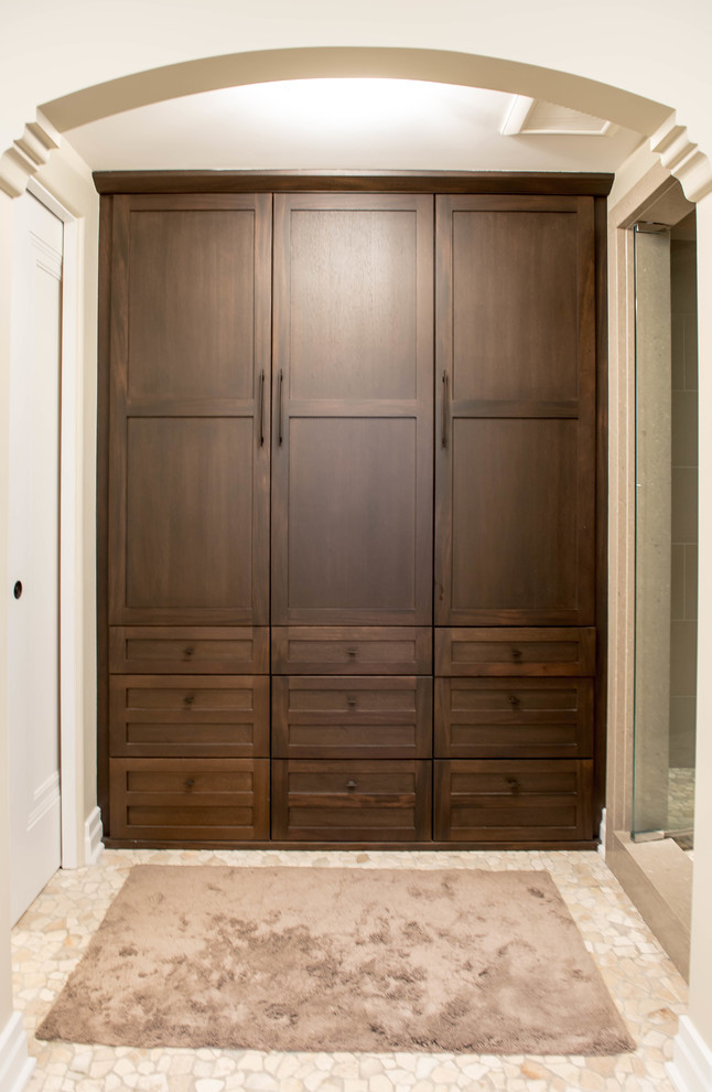 Foto de armario unisex pequeño con armarios estilo shaker, puertas de armario de madera oscura, suelo de mármol y suelo beige