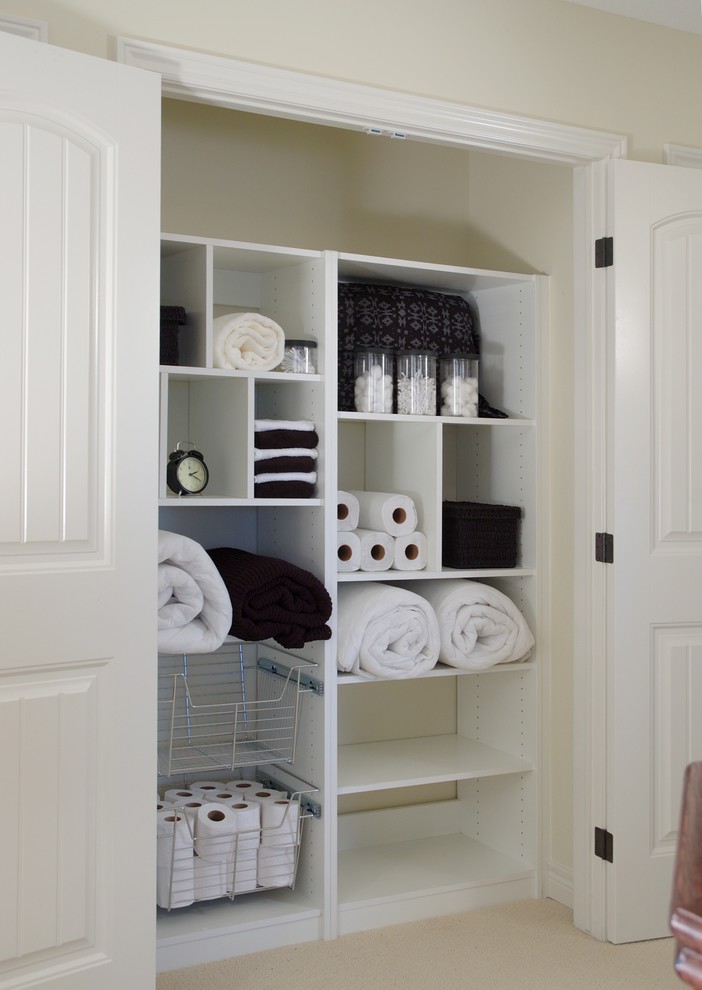 Imagen de armario contemporáneo pequeño con armarios abiertos, puertas de armario blancas, moqueta y suelo beige