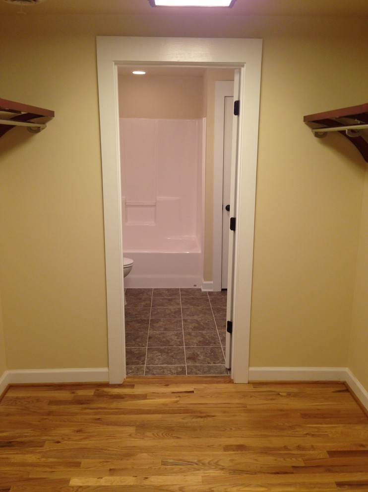 Small arts and crafts medium tone wood floor walk-in closet photo in Charlotte