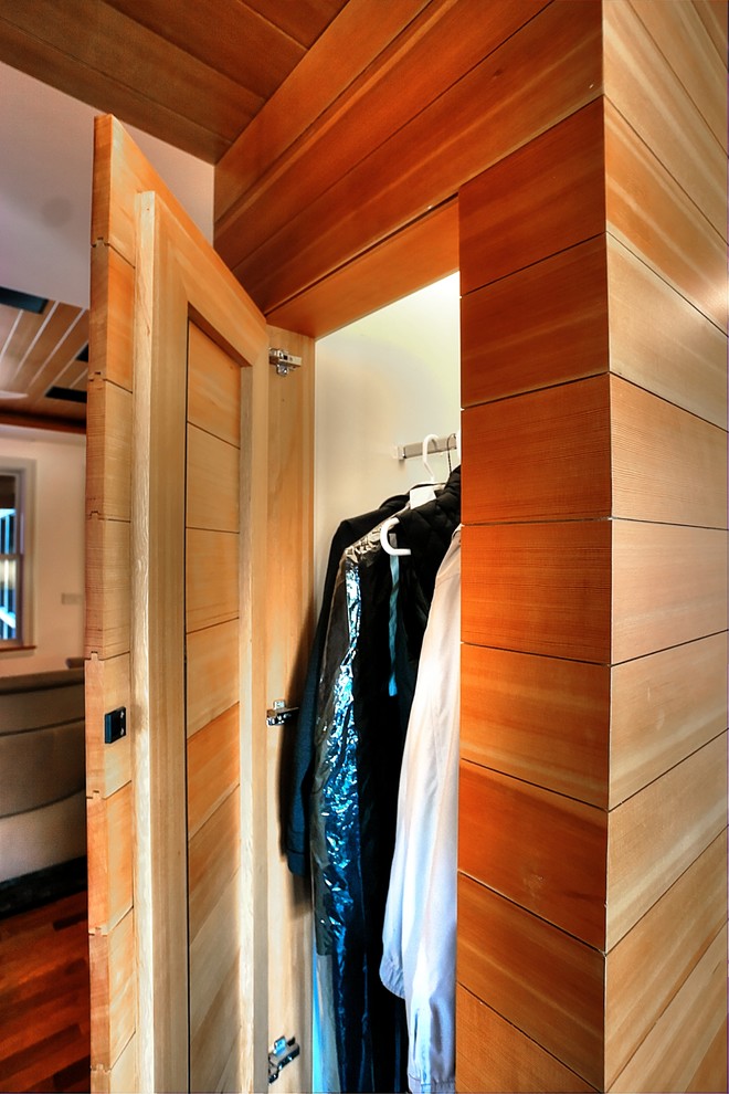 Esempio di un piccolo armadio o armadio a muro unisex minimal con ante lisce e ante in legno scuro