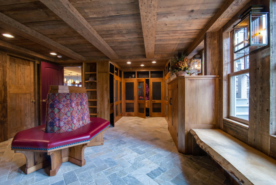 На фото: большая гардеробная комната унисекс в стиле рустика с фасадами в стиле шейкер, фасадами цвета дерева среднего тона, полом из сланца и серым полом