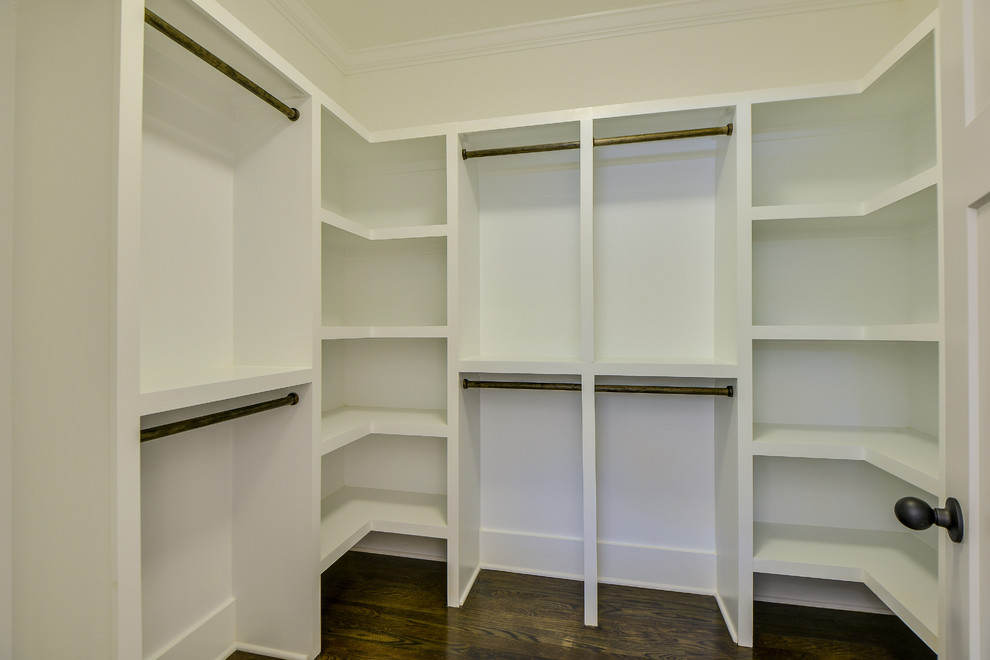 Ejemplo de armario vestidor unisex de estilo americano con puertas de armario blancas y suelo de madera en tonos medios