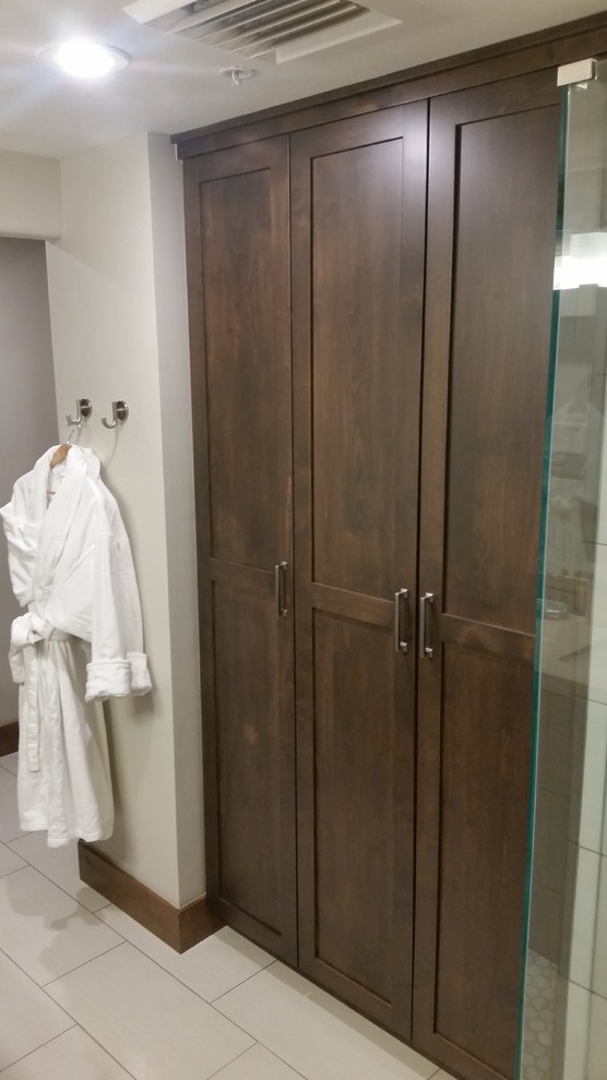 Diseño de vestidor unisex tradicional de tamaño medio con armarios estilo shaker, puertas de armario marrones, suelo de baldosas de terracota y suelo blanco