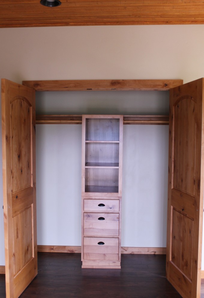 Ejemplo de armario unisex rústico de tamaño medio con armarios estilo shaker, puertas de armario de madera oscura, suelo laminado y suelo marrón