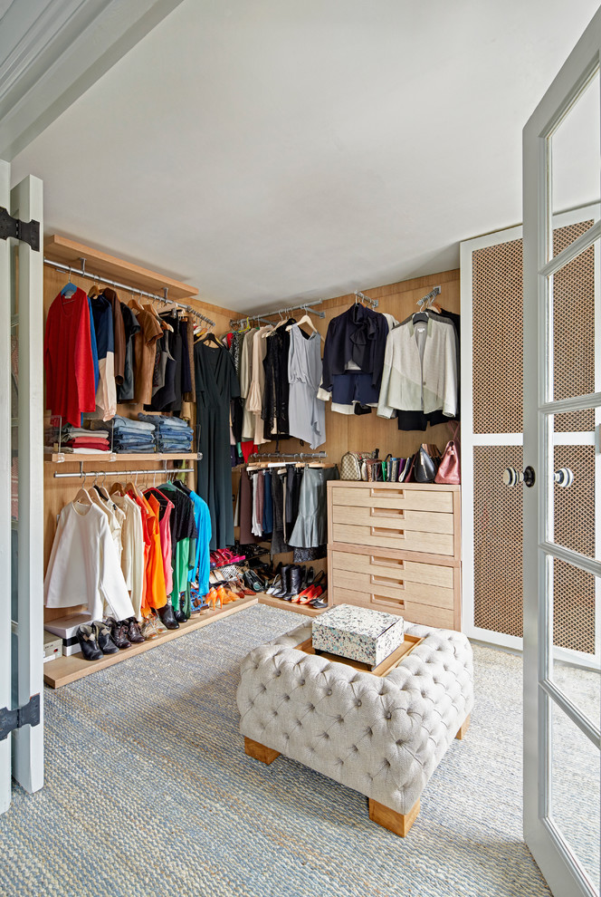 Ejemplo de vestidor unisex clásico renovado con armarios con paneles lisos, puertas de armario de madera clara y moqueta