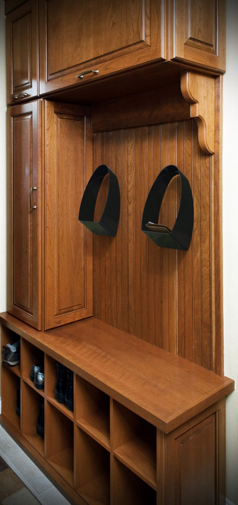 Cette image montre un dressing traditionnel en bois brun de taille moyenne et neutre avec un placard avec porte à panneau surélevé.