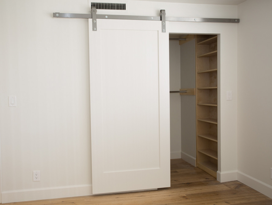 Inspiration for a medium sized traditional gender neutral walk-in wardrobe in Los Angeles with recessed-panel cabinets, light wood cabinets, medium hardwood flooring and brown floors.