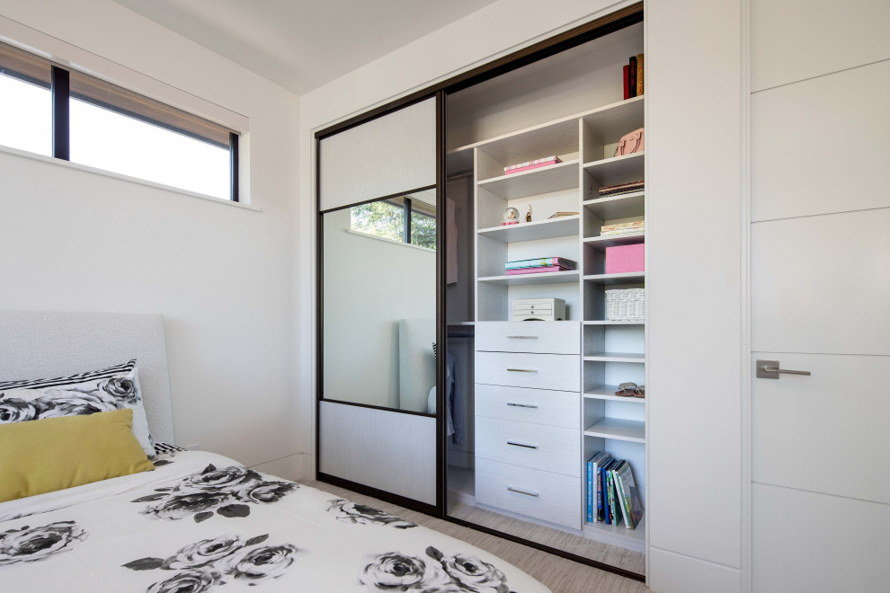 This is an example of a small contemporary standard wardrobe for women in San Francisco with open cabinets, white cabinets, carpet and grey floors.