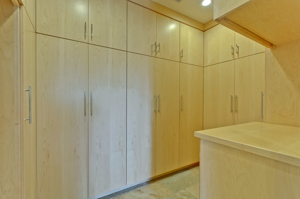 Foto de vestidor unisex retro grande con armarios con paneles lisos, puertas de armario de madera clara, suelo de pizarra y suelo beige