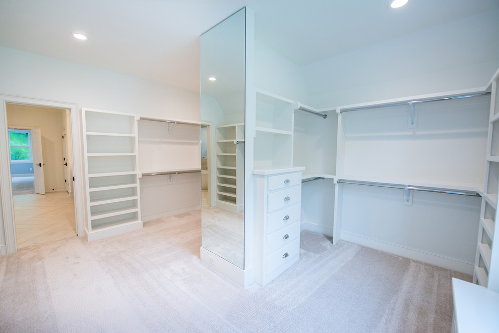 Ejemplo de armario vestidor unisex de estilo de casa de campo con puertas de armario blancas, moqueta y suelo beige