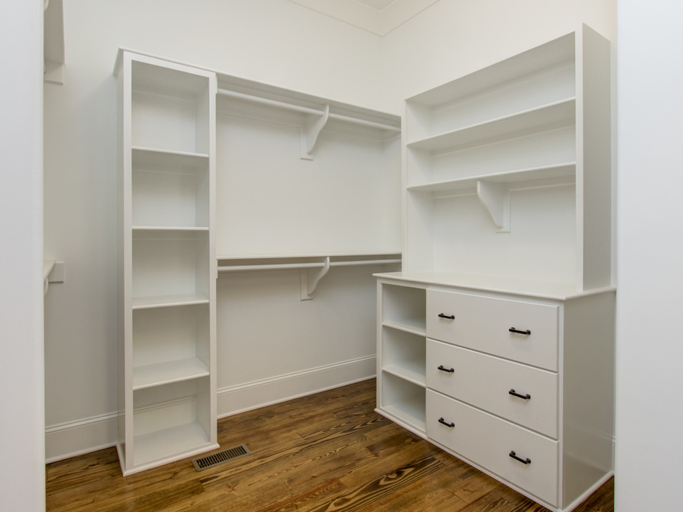 Large classic gender neutral walk-in wardrobe in Other with flat-panel cabinets, white cabinets and medium hardwood flooring.