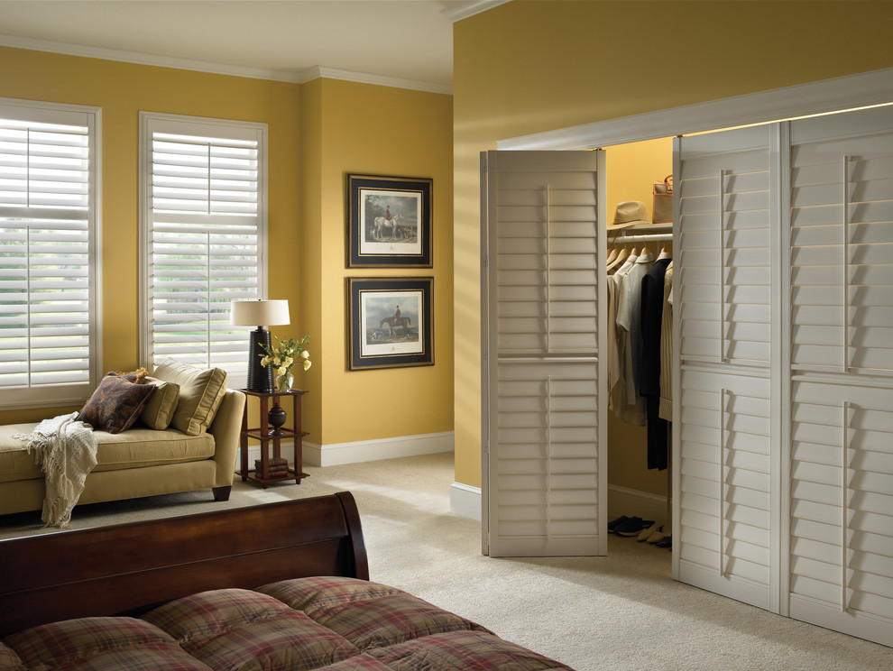 Design ideas for a medium sized traditional gender neutral standard wardrobe in Atlanta with louvered cabinets and carpet.