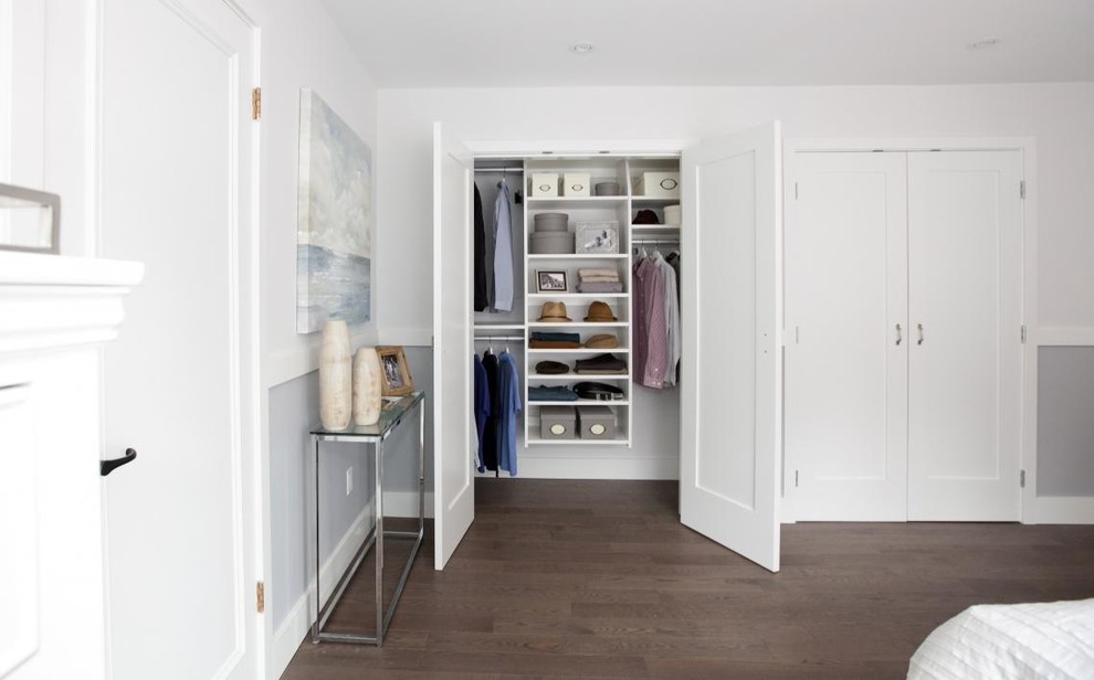 Immagine di un piccolo armadio o armadio a muro unisex tradizionale con ante bianche e pavimento in legno massello medio