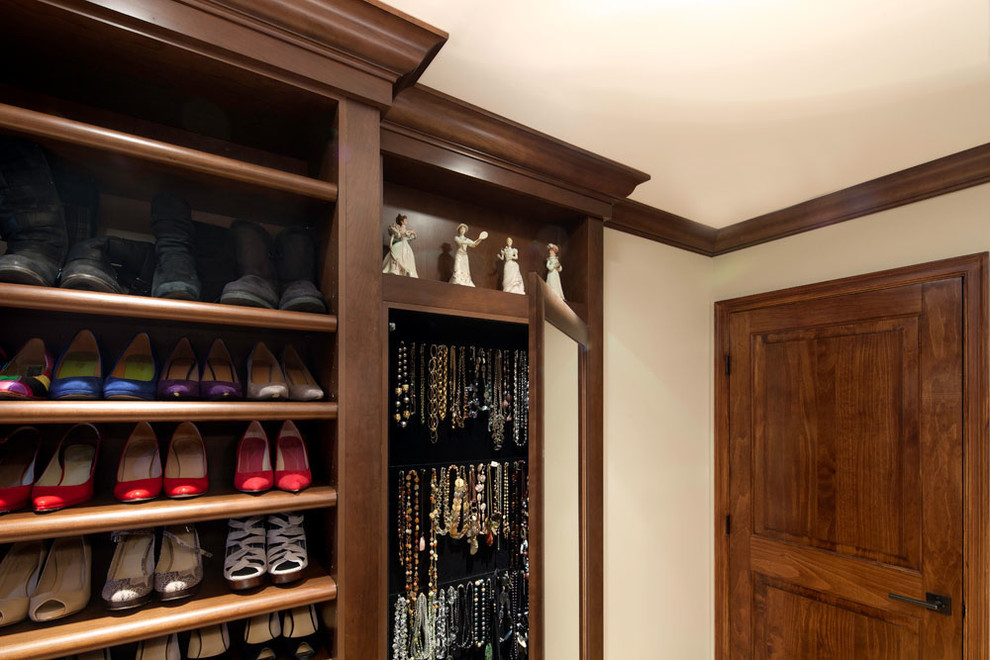 Imagen de vestidor de mujer clásico grande con armarios abiertos y puertas de armario de madera en tonos medios