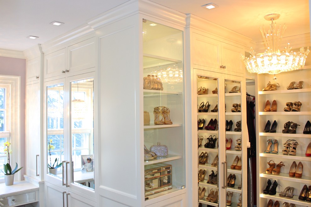 Example of a large trendy gender-neutral dark wood floor walk-in closet design in New York with recessed-panel cabinets and white cabinets