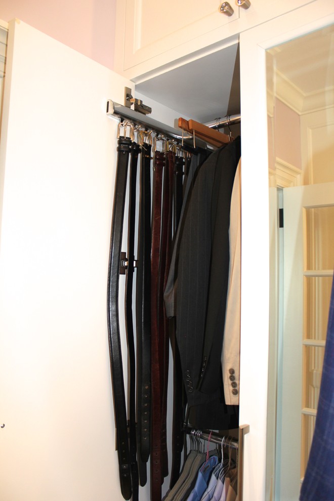 Ejemplo de armario vestidor unisex actual grande con armarios con paneles empotrados, puertas de armario blancas y suelo de madera oscura