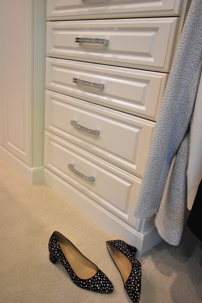 Foto di un ampio spazio per vestirsi unisex chic con ante con bugna sagomata, ante bianche, moquette e pavimento beige