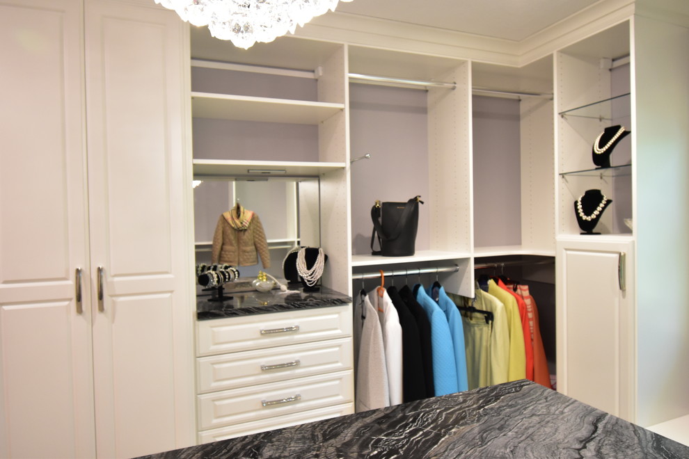 Exemple d'un très grand dressing room chic neutre avec un placard avec porte à panneau surélevé, des portes de placard blanches, moquette et un sol beige.