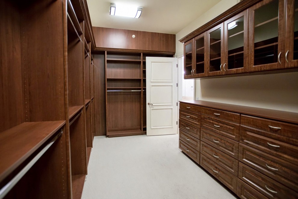 Immagine di una grande cabina armadio unisex minimalista con nessun'anta, ante in legno bruno e moquette