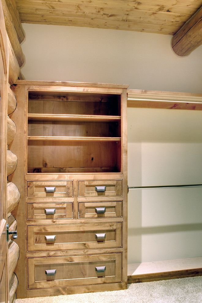 Modelo de armario vestidor unisex rústico de tamaño medio con armarios con paneles empotrados, puertas de armario de madera oscura, moqueta y suelo beige