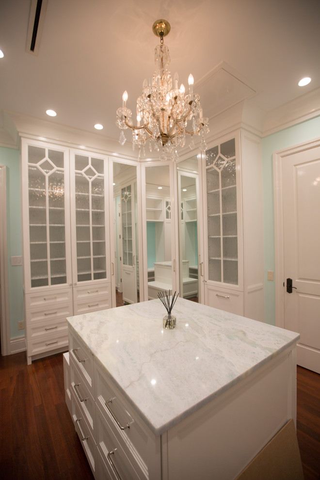 Photo of a large traditional walk-in wardrobe for women in Tampa with shaker cabinets, white cabinets, medium hardwood flooring and brown floors.