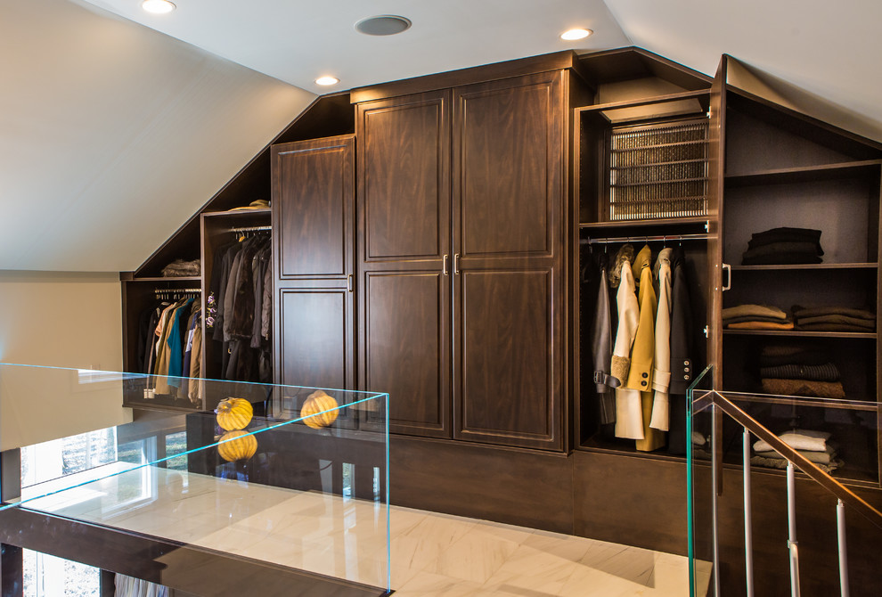 Imagen de armario vestidor clásico grande con armarios con paneles con relieve, puertas de armario de madera en tonos medios y suelo de mármol