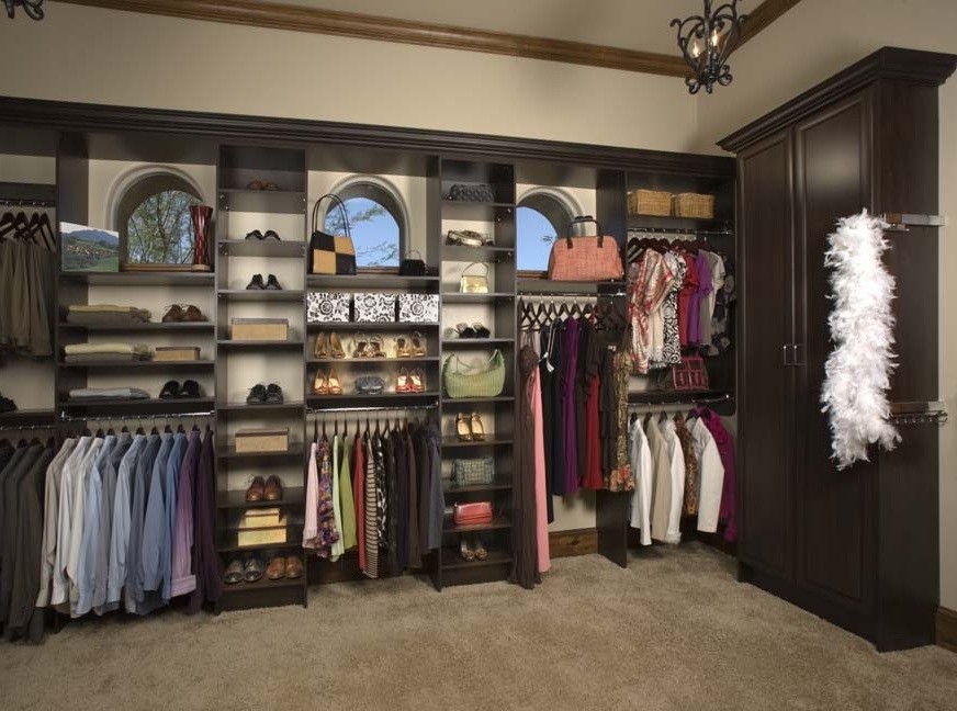 Design ideas for a large classic gender neutral walk-in wardrobe in Burlington with dark wood cabinets, carpet, beige floors and open cabinets.
