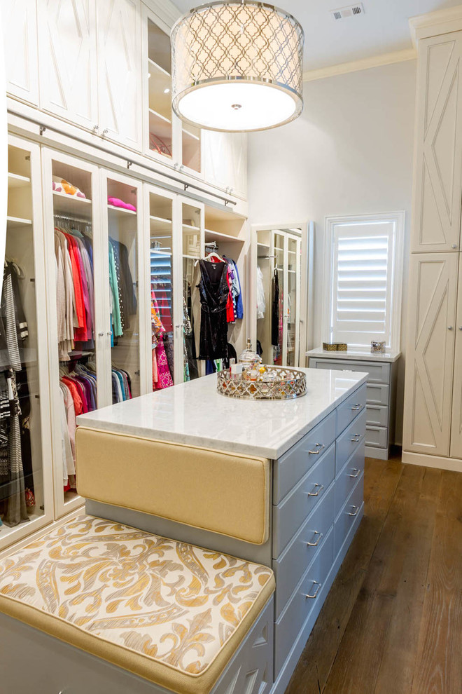 Diseño de armario vestidor de mujer actual grande con armarios con paneles lisos, puertas de armario de madera clara y suelo de madera en tonos medios