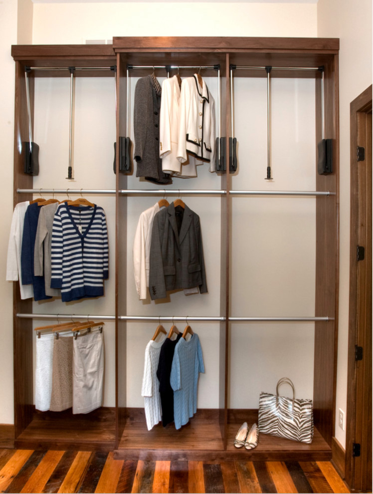 Imagen de armario vestidor grande con armarios con paneles lisos, puertas de armario de madera oscura y suelo de madera en tonos medios